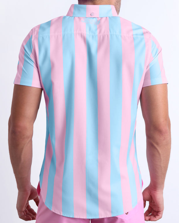 Male model wearing men’s THE KEN (IBIZA EDITION) men’s Summer button-down featuring pastel pink and blue colored stripes. This beach top is designed by BANG! Clothes in Miami.
