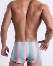 Back view of the THE KEN (MALIBU EDITION) Swim Shorts for men. Inspired by the Barbie movie SoBe/Art-Deco-pastels in pink and pastel light aqua-green stripes, these briefs are designed by BANG! Clothes in Miami.