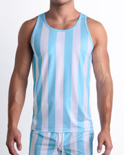 Male model wearing THE KEN (MYKONOS EDITION) casual Tank Top with matching Resort Shorts, in white and light blue-colored stripes inspired by the styles seen worn by Ryan Gosling as Ken, in the Barbie movie. Designed by BANG! Clothes, a men’s beachwear brand from Miami.