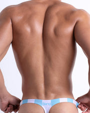 Back view of the THE KEN (MYKONOS EDITION) for men’s bikini-style Thongs. Inspired by the Barbie movie SoBe/Art-Deco-pastels in white and pastel blue stripes, this swimsuit are designed by BANG! Clothes in Miami.