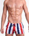 BANG The Ken (Saint-Tropez Edition) Show Shorts — model wearing red, white, and navy vertical stripe show shorts inspired by classic Riviera beach style, featuring a tailored short-length silhouette and adjustable drawstring waistband.