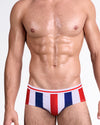 BANG The Ken (Saint-Tropez Edition) Swim Brief — front view featuring bold vertical red, white, and navy stripes with a classic low-rise silhouette and contoured pouch design.