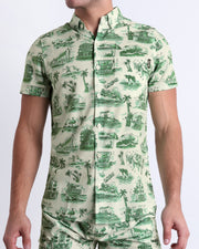 Front view of the TOILE DE MIAMI (GREEN) men’s sleeveless stretch shirt and the matching shorts for a complete look in beige and dark green-colored toile de jouy-inspired print. Designed by BANG! Clothes, a men’s beachwear brand from Miami.
