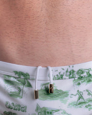 Close-up view of the TOILE DE MIAMI (GREEN) men’s drawstring briefs showing white cord with custom branded golden cord ends, and matching custom eyelet trims in gold.