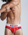 Front view of a sexy male model wearing a BANG! cotton briefs for men in the TRIUMPH a red color with blue and red details offering a perfect fit that sits low for a contemporary fit. 