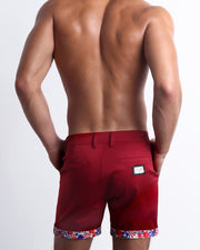 Back view of a model wearing woven twill cotton chino shorts in a crimson red color for men. These premium quality swimwear bottoms are DC2 by BANG! Clothes, a men’s beachwear brand from Miami.