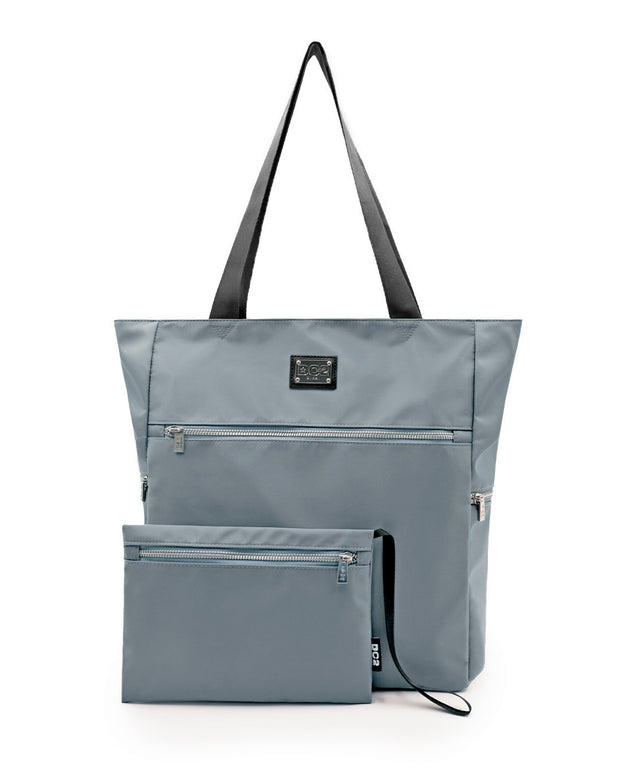 Front view of the VACAY GRAY Poolside Tote Bag by DC2 Miami, featuring a sleek solid light grey. The tote is spacious with durable black handles and multiple zippered compartments, including a detachable pouch with a matching color. Made from high-quality, water-resistant material, this versatile tote bag is perfect for beach outings or casual everyday use.