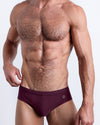 DC2 Spring/Summer 2025 collection — model wearing VERY BERRY swim briefs, featuring a rich berry tone in a sleek low-rise cut.