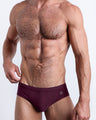 DC2 Spring/Summer 2025 collection — model wearing VERY BERRY swim briefs, featuring a rich berry tone in a sleek low-rise cut.