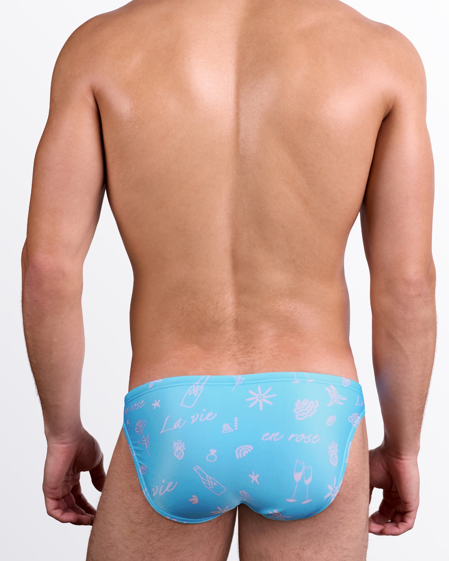 DC2 Viva La Vida (En Rose) Swim Mini Brief — back view highlighting the allover pink doodle-style artwork on turquoise fabric with contoured low-rise mini brief fit.
