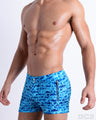 Side view of the WET men’s summer Beach Shorts, with dual zippered pockets. These shorts with a stylish DC2 logo monogram motif made by DC2, a men’s beachwear brand from Miami.