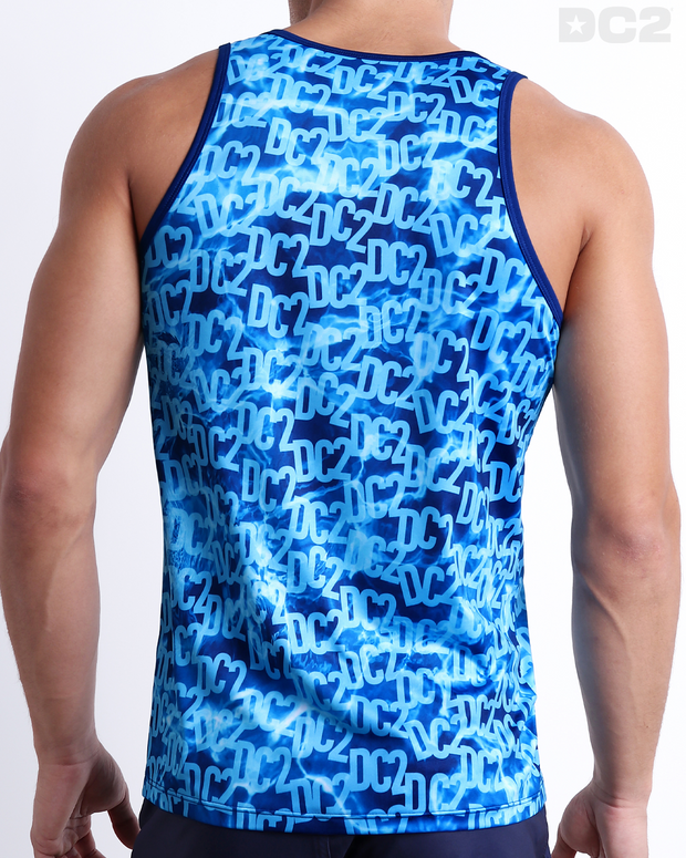 Male model wearing men’s WET men’s Summer Tank Top in a stylish monogram print of the DC2 logo in multiple shades of blue. This high-quality shirt is by DC2, a men’s beachwear brand from Miami.