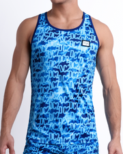 Male model wearing WET men’s casual Tank Top and the matching beach shorts. A premium quality swim set with a DC2 logo monogram motif in blue print, a men’s beachwear brand from Miami.