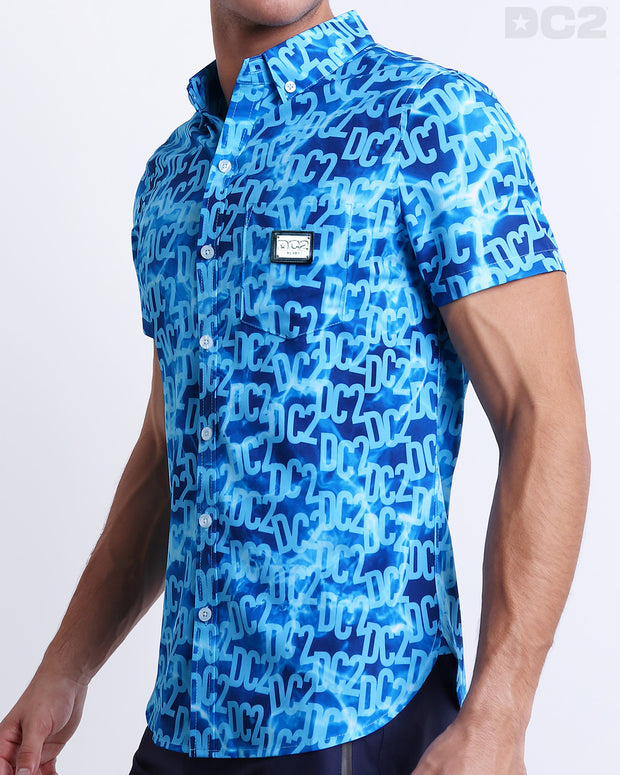 Side view of the WET Hawaiian-inspired Stretch Shirt for men in a stylish monogram print of the DC2 logo in multiple shades of blue, complete with a front pocket, made by DC2 a capsule brand by BANG! Clothes in Miami.