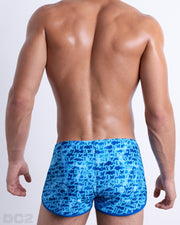 Back view of the WET beach sexy swimming bottoms for men. This swimsuit has a stylish monogram print of the DC2 logo in multiple shades of blue for men made by DC2 a brand based in Miami.