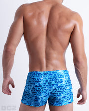 Back view of male model wearing the WET beach sexy swimming bottoms in a monogram print of the DC2 logo print, designed by DC2.