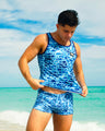 Male model wearing WET Swim Trunks and matching tank top by DC2 Miami, featuring an all-over blue logo print. Stylish men's beachwear set for summer and poolside activities.