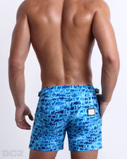 Male model wearing a men’s WET beach Tailored Shorts swimsuit, complete with a back pocket, designed by DC2 a capsule brand by BANG! Clothes based in Miami.