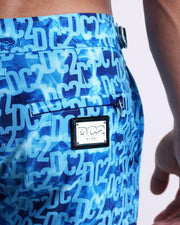 Close-up view of the WET men’s swimwear, showing custom-branded silver logo plaque.