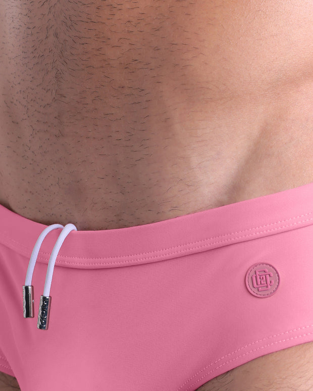 Close-up view of the WHISPERING ROSE men’s drawstring briefs showing white cord with custom branded metallic silver cord ends, and matching custom eyelet trims in silver.