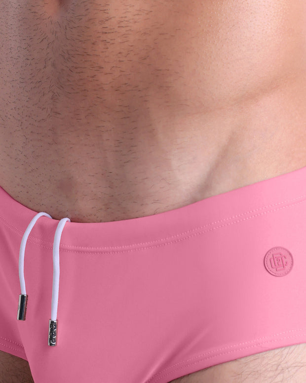 Close-up view of the WHISPERING ROSE men’s drawstring briefs showing white cord with custom branded metallic silver cord ends, and matching custom eyelet trims in silver.