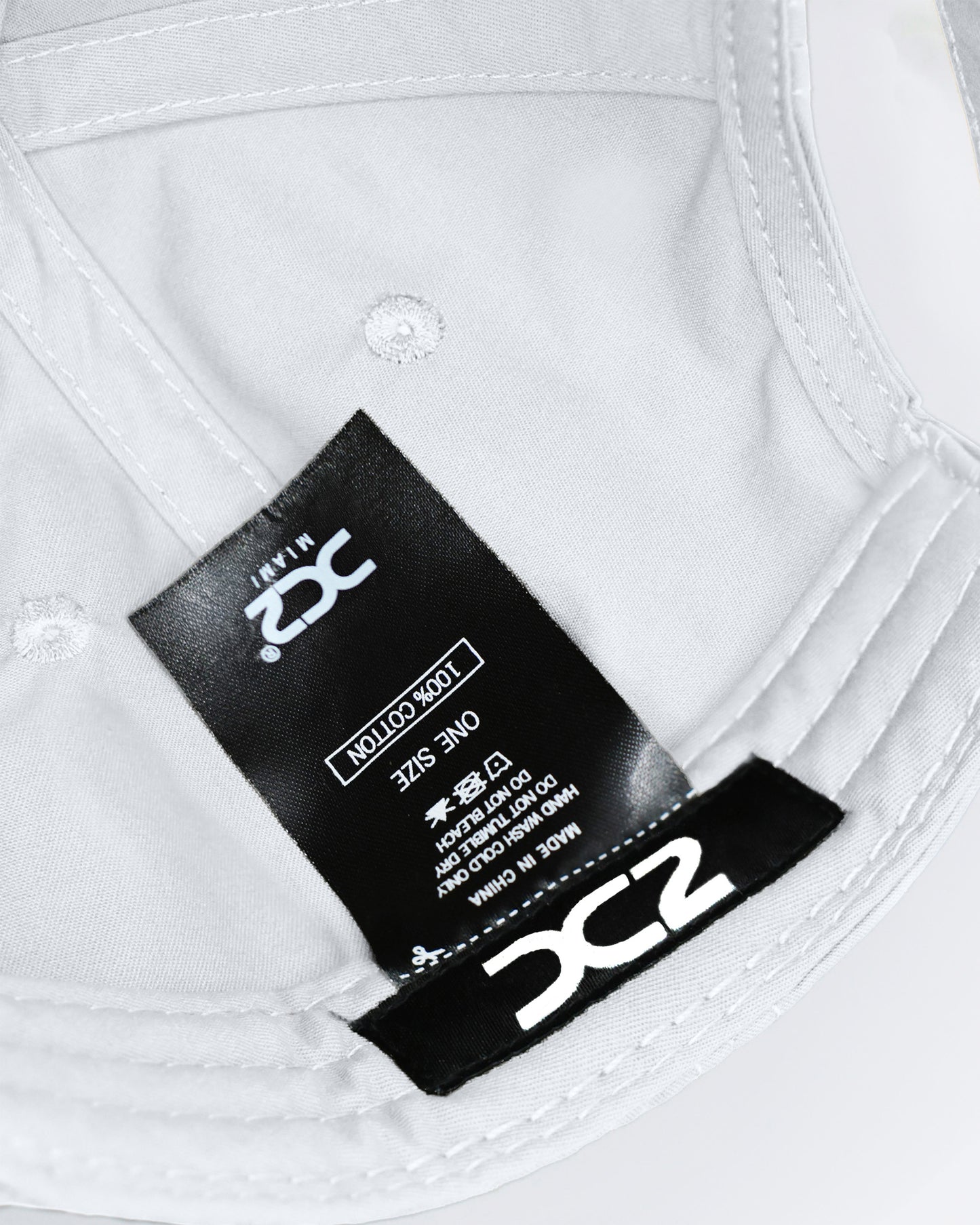 Interior view of the DC2 White Resort Cap — showing soft cotton lining, branded label, and adjustable construction.