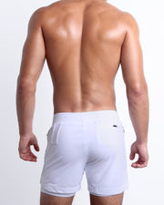 Back view of the WHITE men's fitness compression lined workout shorts in a white color. These premium quality quick-dry endurance shorts are DC2 by BANG! Clothes, a men’s beachwear brand from Miami.