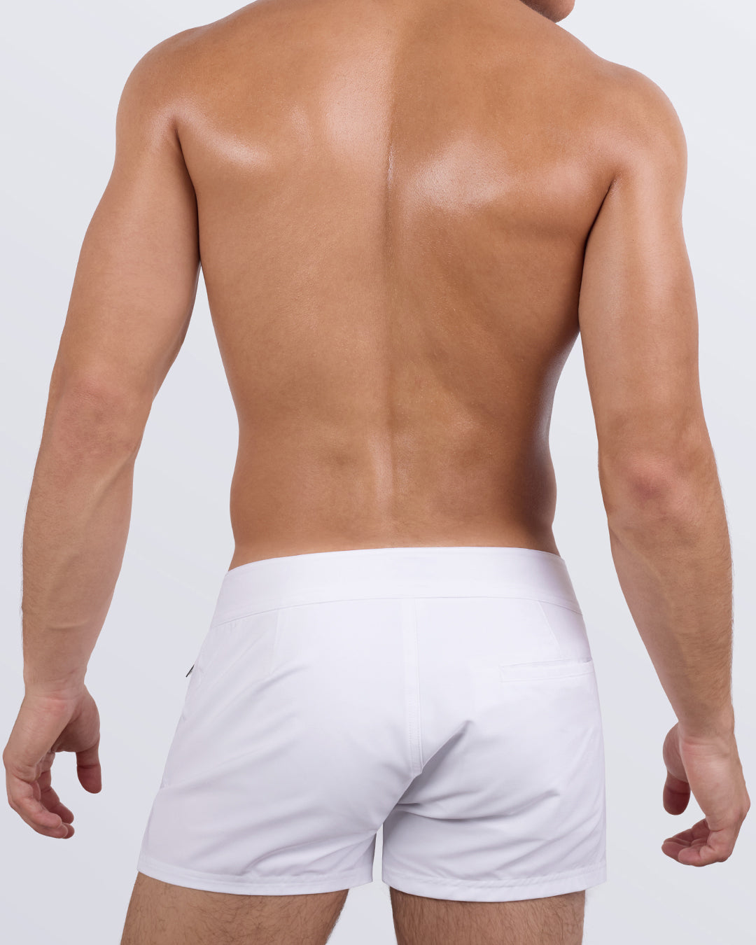 Back view of the White Party Beach Shorts showing the smooth white finish, fitted silhouette, and streamlined back welt pocket.