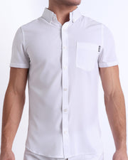 Front view of a sexy male model wearing WHITE PARTY mens short-sleeve stretch shirt in a solid white color by the Bang! brand of men's beachwear from Miami.