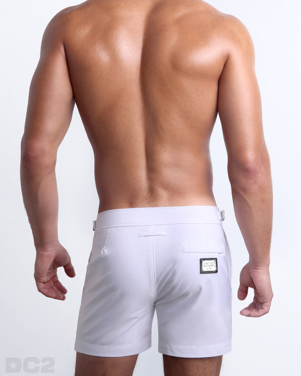 Back view of a male model wearing the WHITE PARTY Tailored Shorts men’s beach shorts in a white, complete with a back zippered pocket, designed by DC2 a BANG! Clothes capsule brand in Miami.