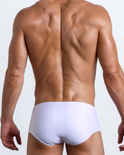 Back view of a male model wearing men’s swim sungas in white color by the Bang! Clothes brand of men's beachwear from Miami.
