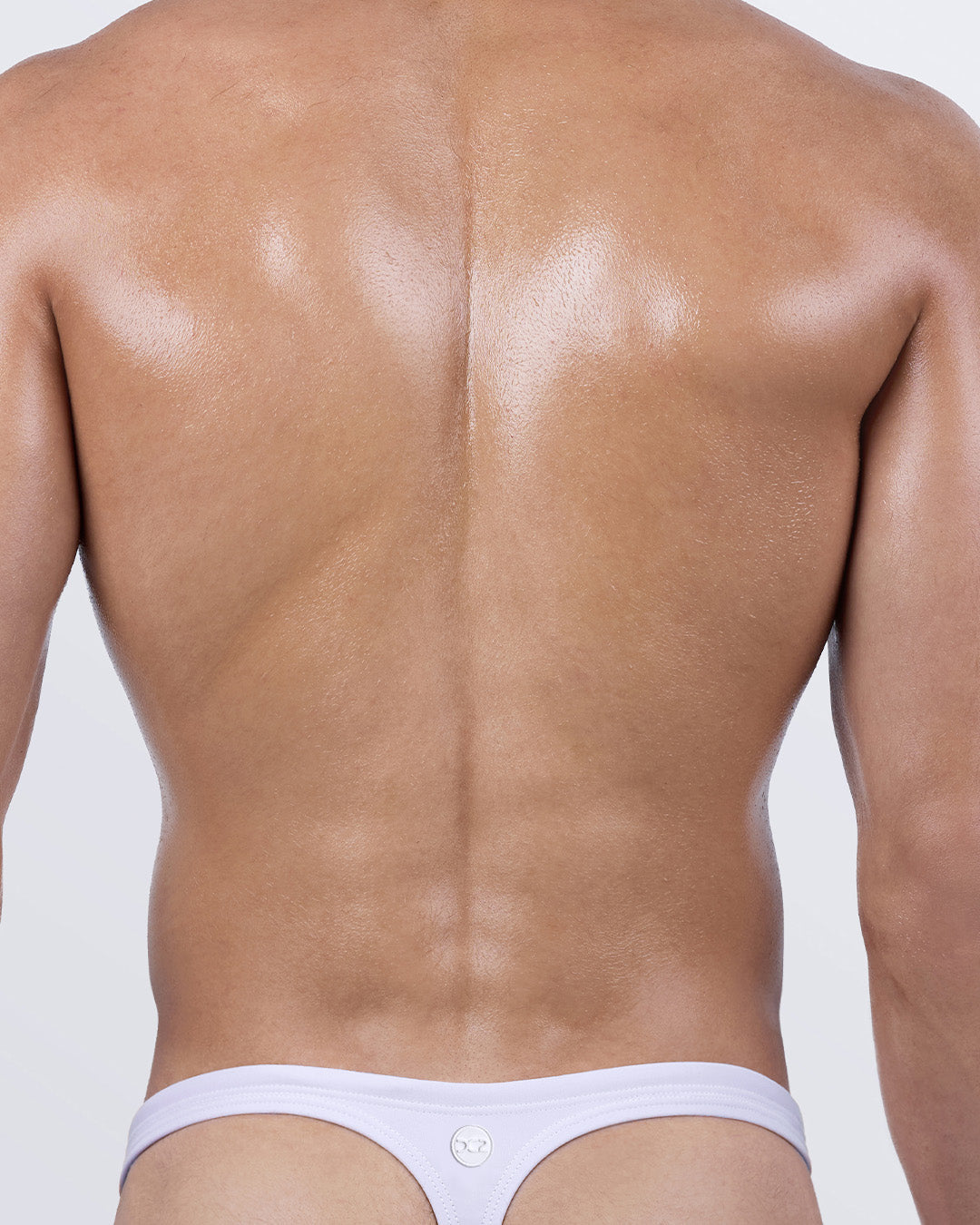 Back view of WHITE PARTY Swim Thong — minimal "T" shape with logo detail, perfect for tanning.