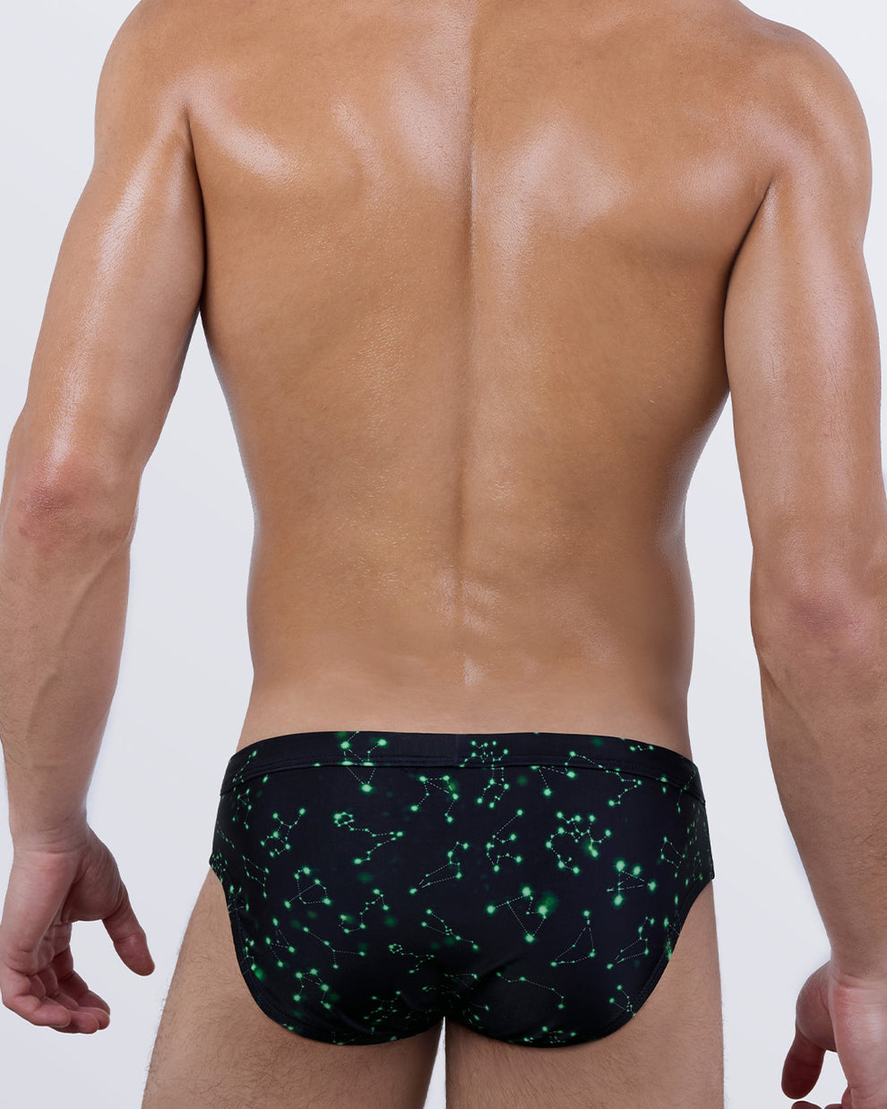 Back view of BANG! Written in the Stars Swim Briefs – men’s designer swimwear with neon green constellation pattern and tailored fit for all-day comfort.