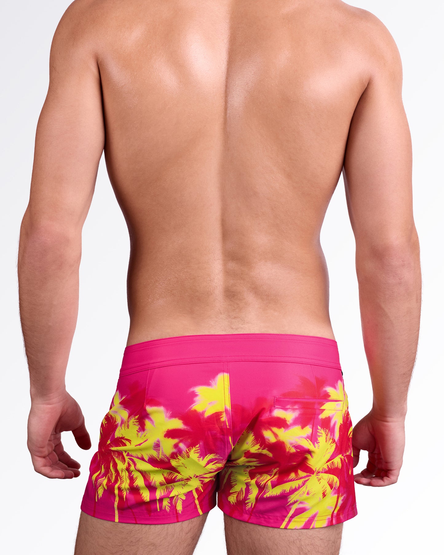 BANG Wuthering Heights (Fucsia) Beach Shorts — back view showcasing the tropical palm print, rear pocket detail, and sleek resort-ready beach fit.