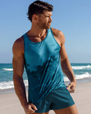 Male model at the beach wearing the Wuthering Heights (Shades) men’s tank top with Chic Teal Poolside Shorts.