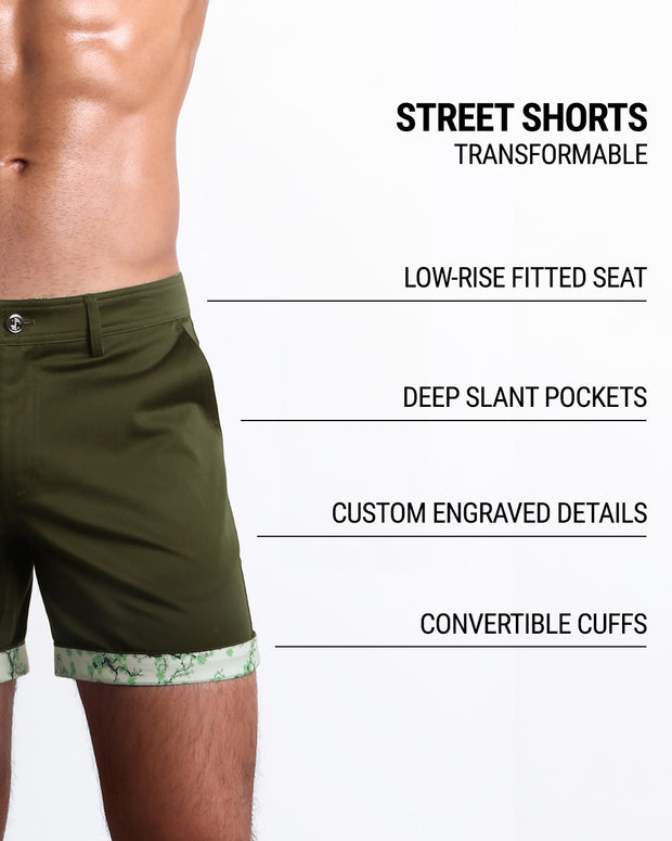 Men tailored fit chino shorts in ZADDY GREEN by DC2 Keeps you feeling comfortable and looking sharp all. Classic chino shorts for men in a cotton blend from DC2 Clothing from Miami. Features two front pockets and custom engraved button front closure with zip fly. Can roll-up cuffs for shorter length and showing internal print. Or hem down for a mid-thigh length and full-solid dark green color showing.