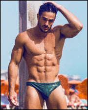 Frontal view of a sexy male model wearing men’s swimsuit in army green  by the Bang! Menswear brand from Miami.
