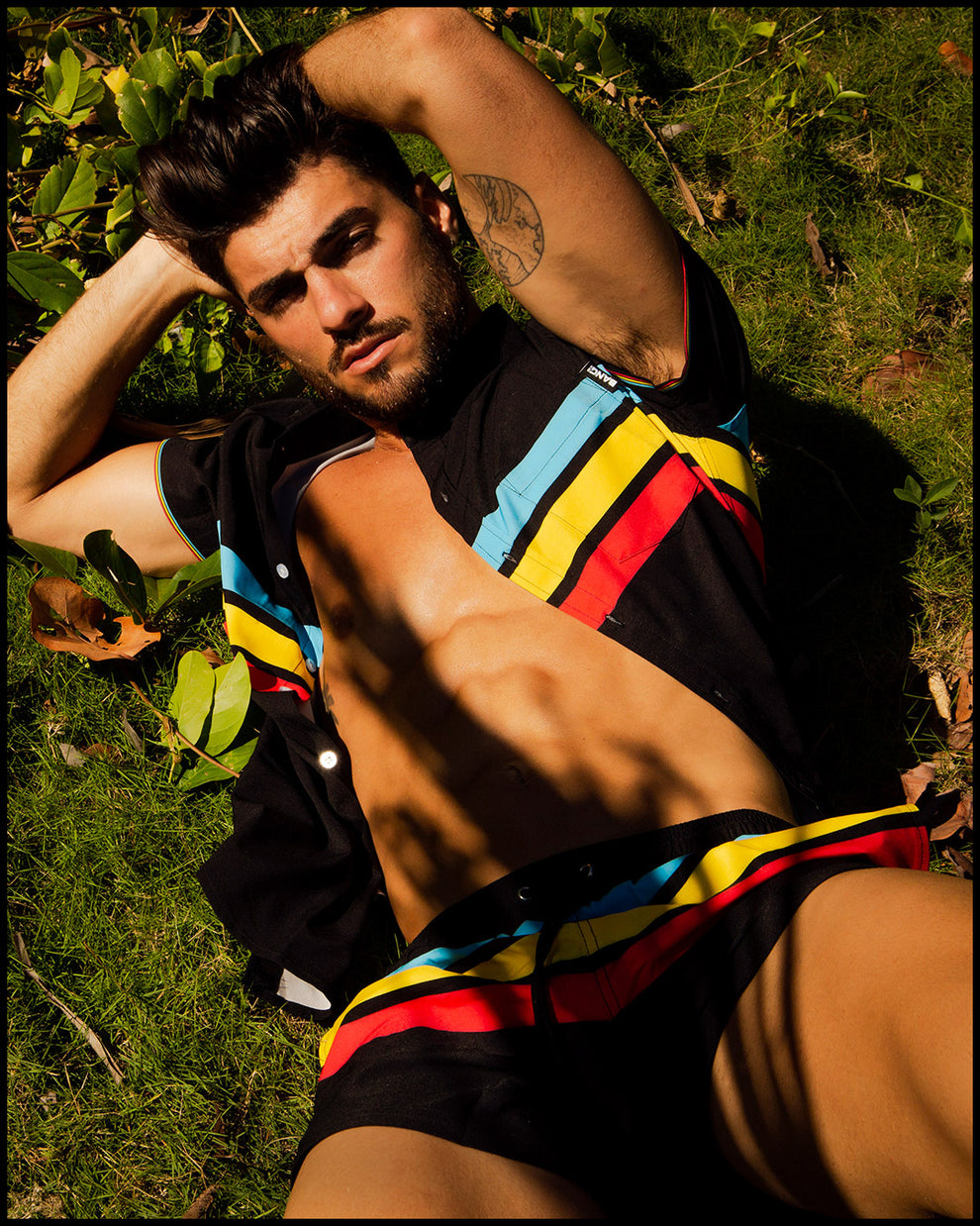 front view of a sexy male model wearing BANG Miami stretch shirt in a bionic stripes print with matching beach shorts 2021 summer body gay south beach