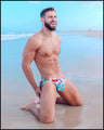 Front view of a sexy male model wearing bang clothes premium swim mini brief yeah yeah print bold colors designer quality fabric