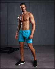 Male model wearing the AERO BLUE Jogger Shorts standing ready to workout. These men’s sport shorts are form-fitting shape of a tight jogger.