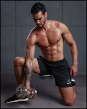 Male model wearing the IRON BLACK Jogger Shorts working out. These men’s sport shorts with the form-fitting shape of a tight jogger.