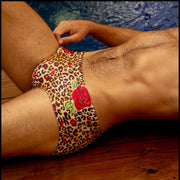 Side view of a sexy male model wearing premium designer quality swim briefs Cats N'Roses, made by the Bang! Brand of men's beachwear.