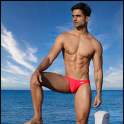 Frontal view of a sexy male model wearing men’s swimsuit in bright red by the Bang! Menswear brand from Miami.