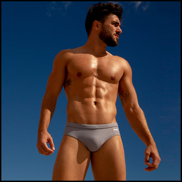 View of a male model wearing men’s swim briefs in stone color by the Bang! Clothes brand of men&