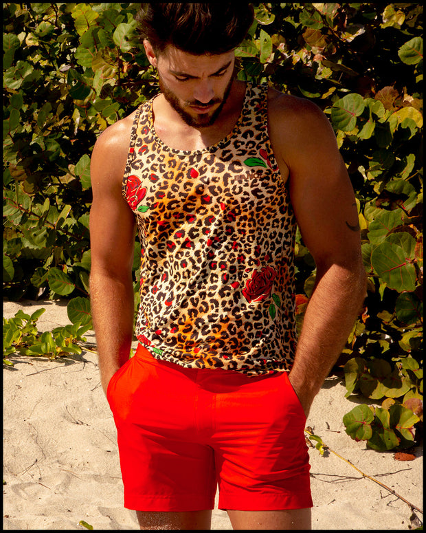 View of a male model wearing the PRIME RED beach trunks for men by BANG! menswear Miami in bright red color and the CATS N&
