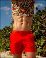 View of model wearing the CATS N'ROSES men’s beach tank top in cotton with leopard print in brown tones with red roses with red color tailored shorts by the Bang! menswear brand.