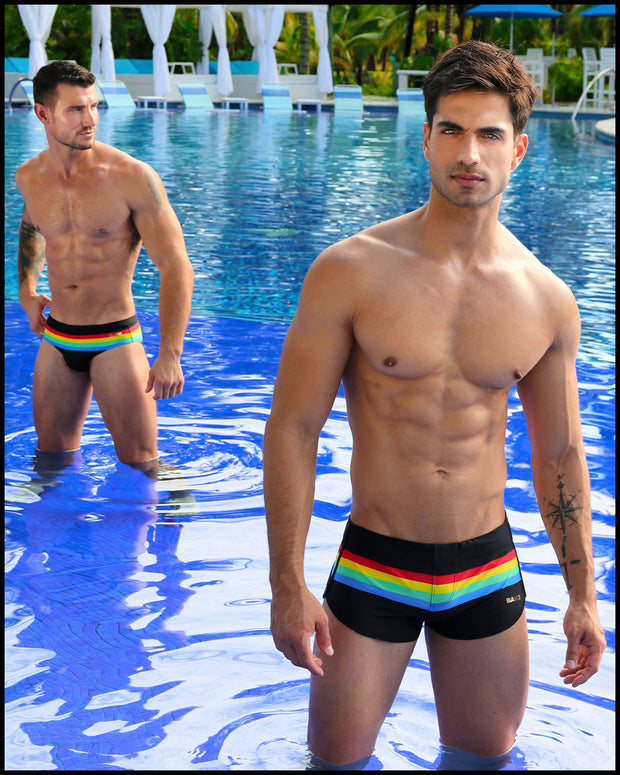 View of sexy male models by the pool the FOUR EVER STRIPES VOL 1 Summer swimsuit for men in dark black with stripes in red, yellow, blue and green by Bang! Clothing of Miami.