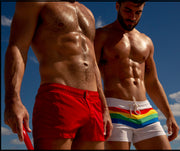 Male model wearing the FOUREVER STRIPES VOL 2 men's beach shorts by the Bang! Clothes brand of men's swimwear from Miami. Next, another model wearing Prime Red Mini Shorts.