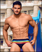 Model wearing the BIONIC Stripes men’s swimsuit by the Bang! brand of men's beachwear from Miami.