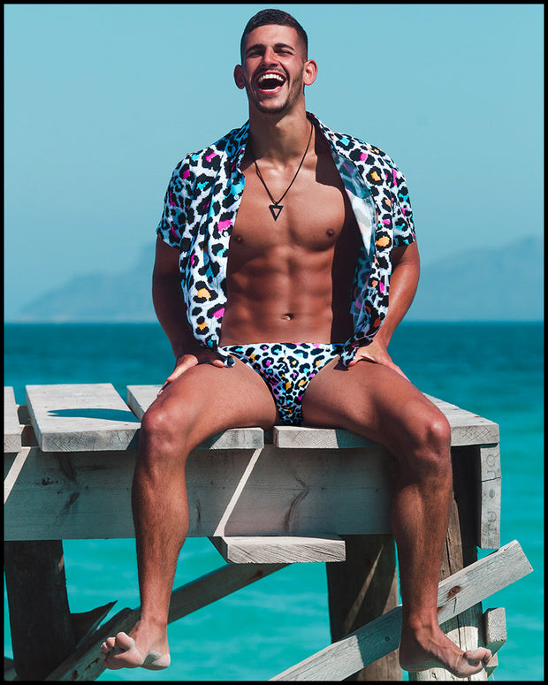 Male model wearing the 8-BIT POP LEOPARD Swimming Briefs and matching Summer button down shirt by Bang Clothing inspired on 80s vintage video games.